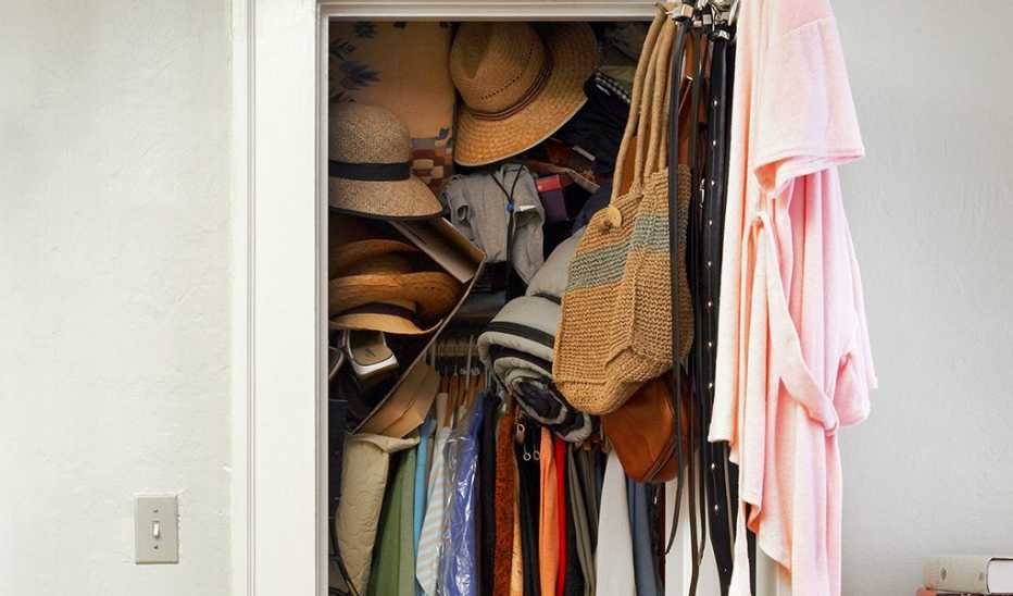 A small closet that is messy and full
