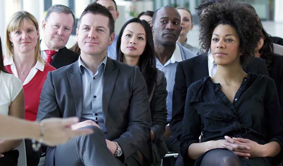 A group of people sitting in a meeting