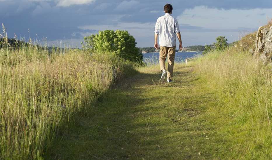 A man walking toward a body of water