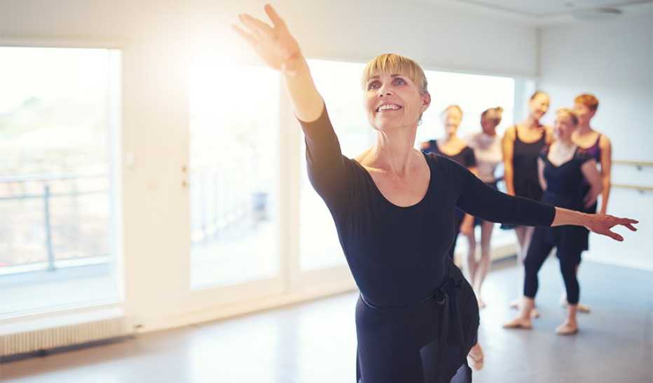 A woman demonstrating a ballet dance to an adult class