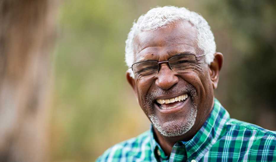 A portrait shot of a man smiling outside