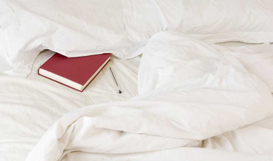 A diary tucked under a pillow on a bed