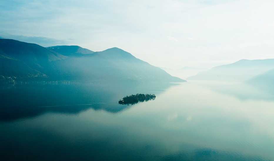 A lake at sunset with mountains in the background