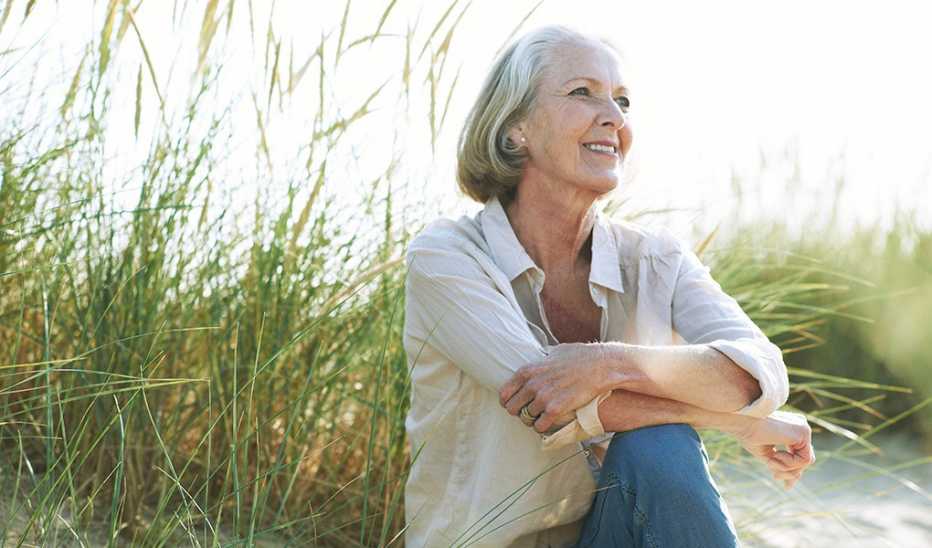 A woman sitting and smiling on a beach