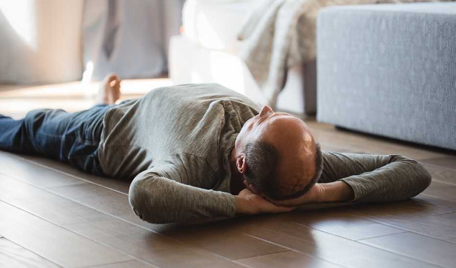A man lying on his back on the floor at home