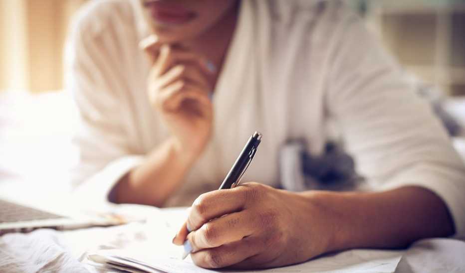 A close-up view of a woman's hand writing