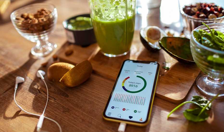 A smoothie and cell phone with a pedometer app on the screen
