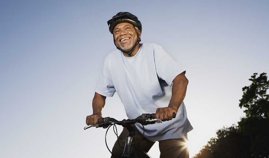 A man smiling and riding a bike