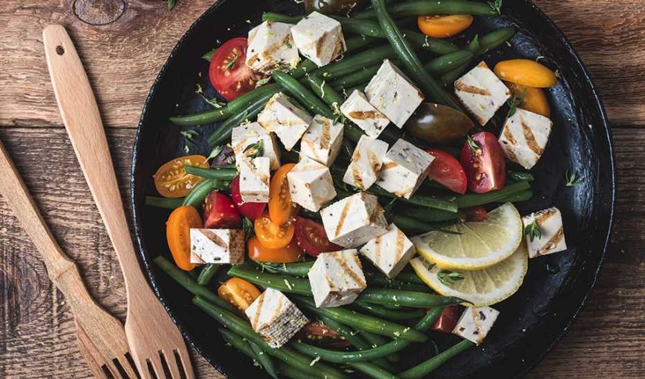 A close-up view of a green bean salad with grilled tofu in a bowl