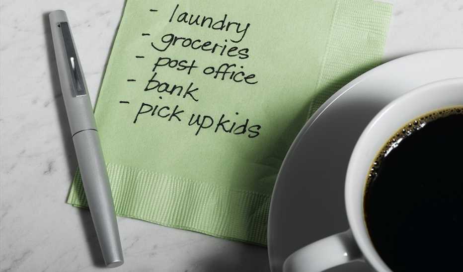A close-up view of a cup of coffee and a to-do list on a napkin