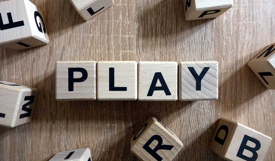 An overhead view of wooden blocks that spell out the word “PLAY”