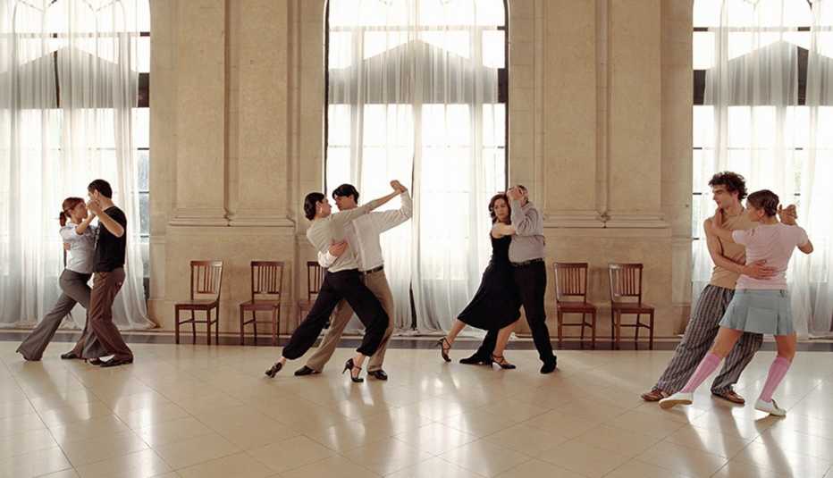 Four sets of men and women ballroom dancing in an open room