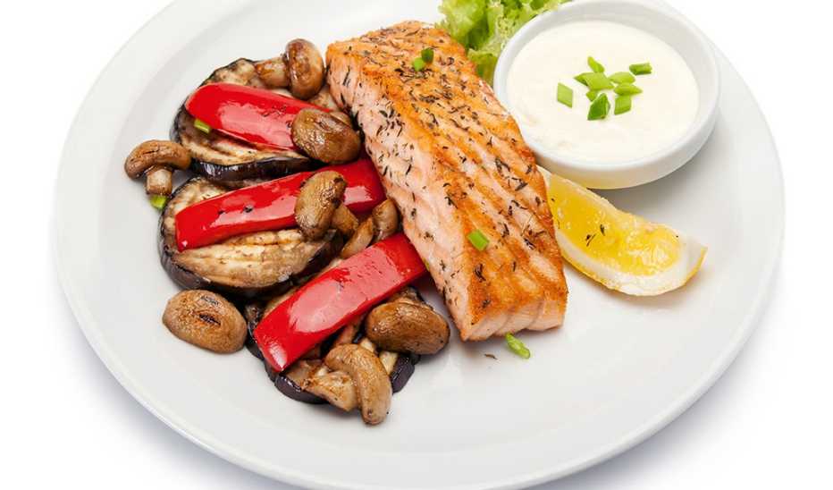 A close-up view of grilled salmon fillet with grilled vegetables on a plate