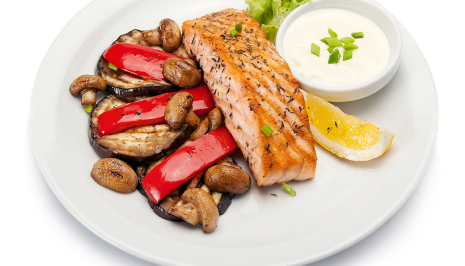 A close-up view of grilled salmon fillet with grilled vegetables on a plate