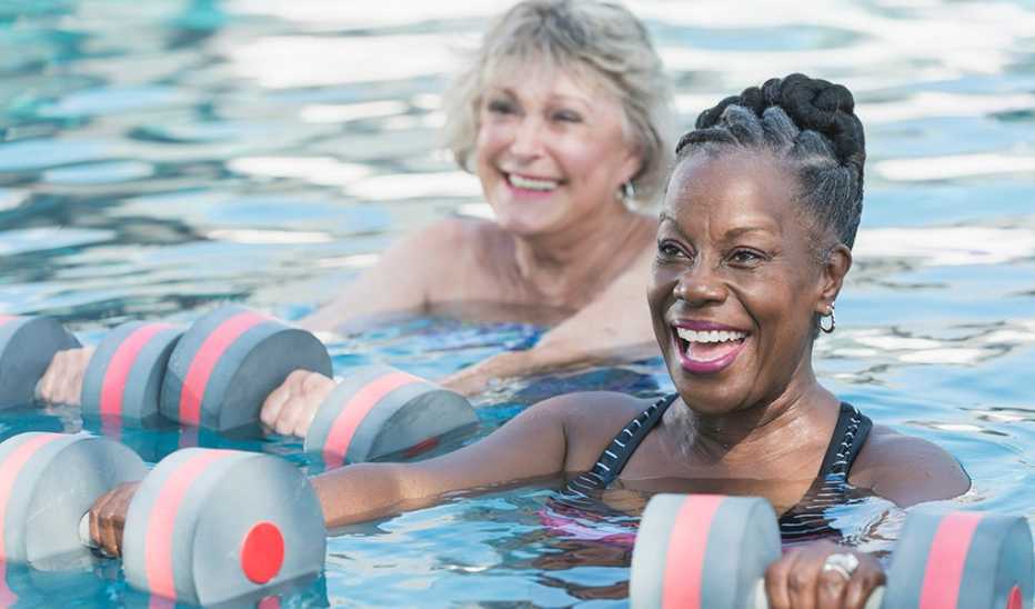 Two smiling women doing water aerobics in a pool