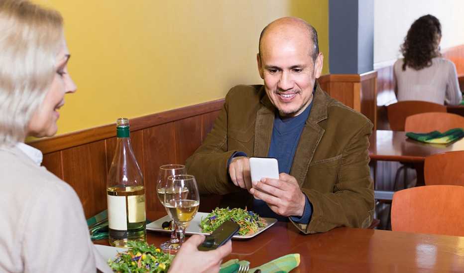 Man and woman distracted by cell phones at a restaurant