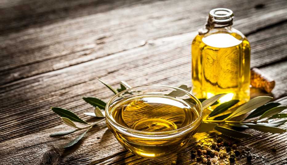 A close-up view of olive oil in a glass bowl and bottle