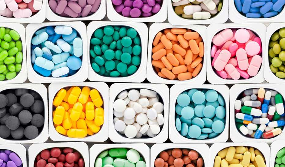 A variety of multicolored brain health supplement pills inside plastic containers
