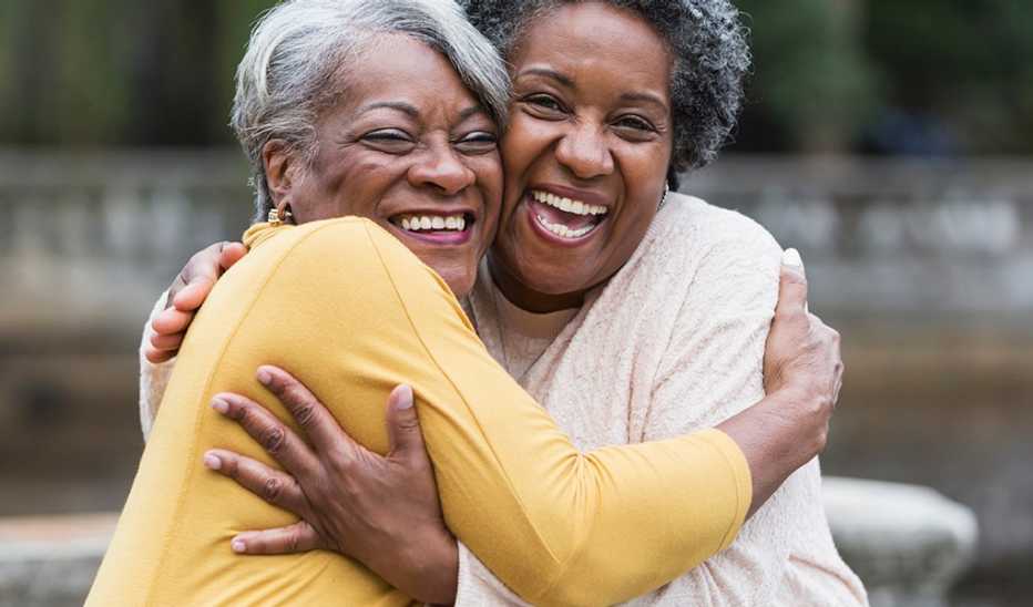 Rekindling friendships may support health and well-being Two women smiling and hugging each other