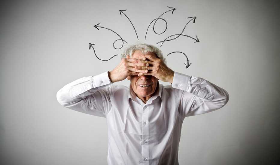 A man with hands over his face and arrows coming out of head