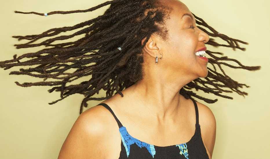 A woman smiling and swinging her hair in a studio