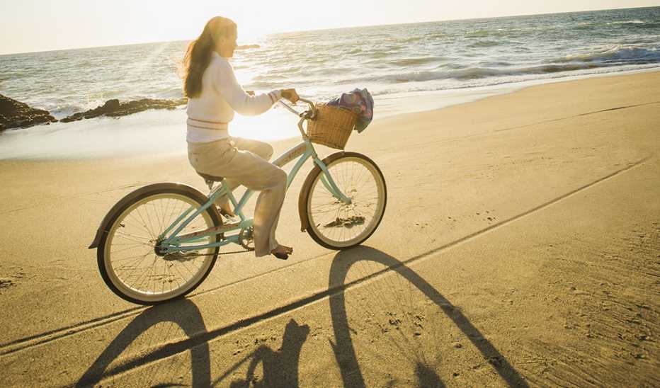 Exercise is essential for anyone under chronic stress A woman riding a bicycle on a beach