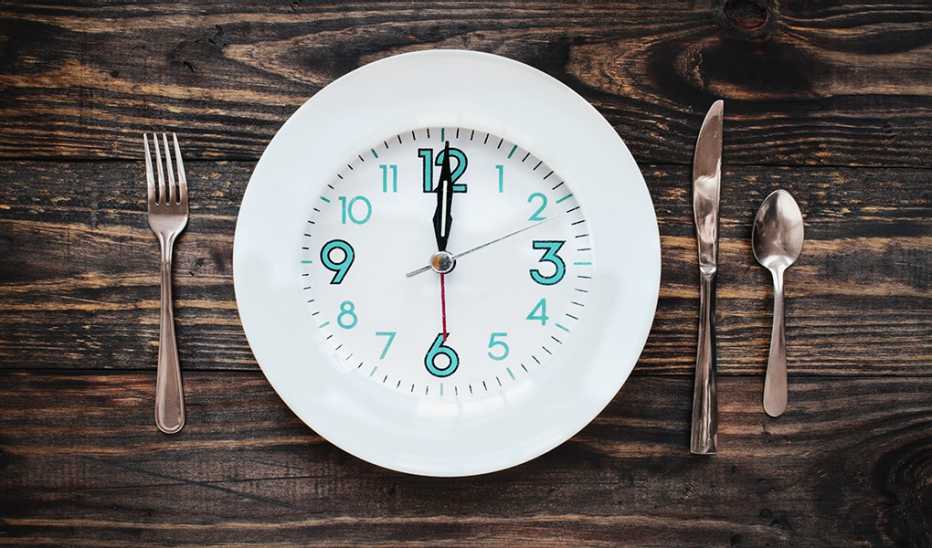 A clock in the form of a plate on a rustic wooden table