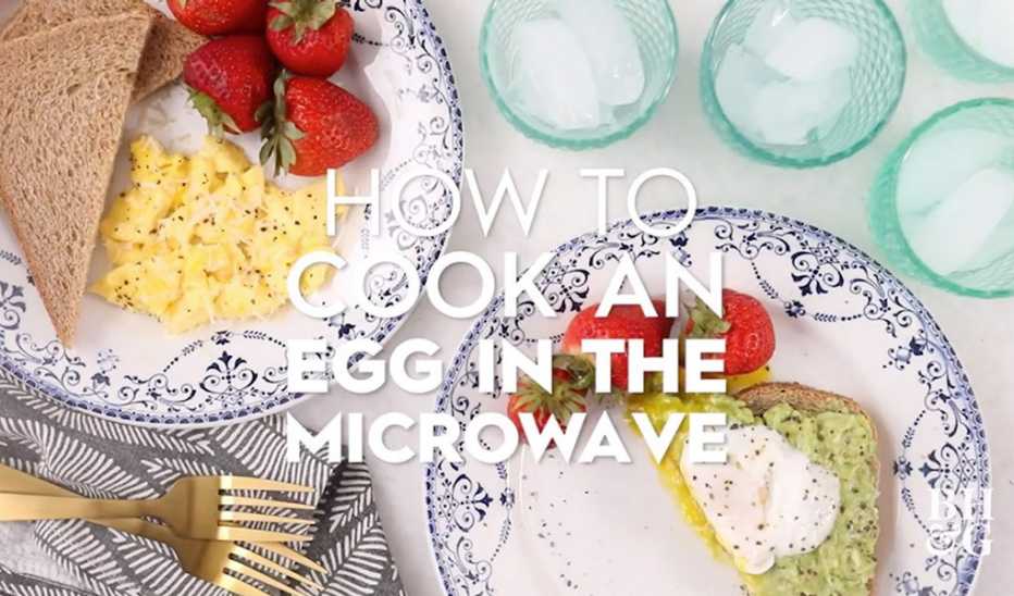 A close-up view of eggs, bread and strawberries on plates with the text "how to cook an egg in the microwave"