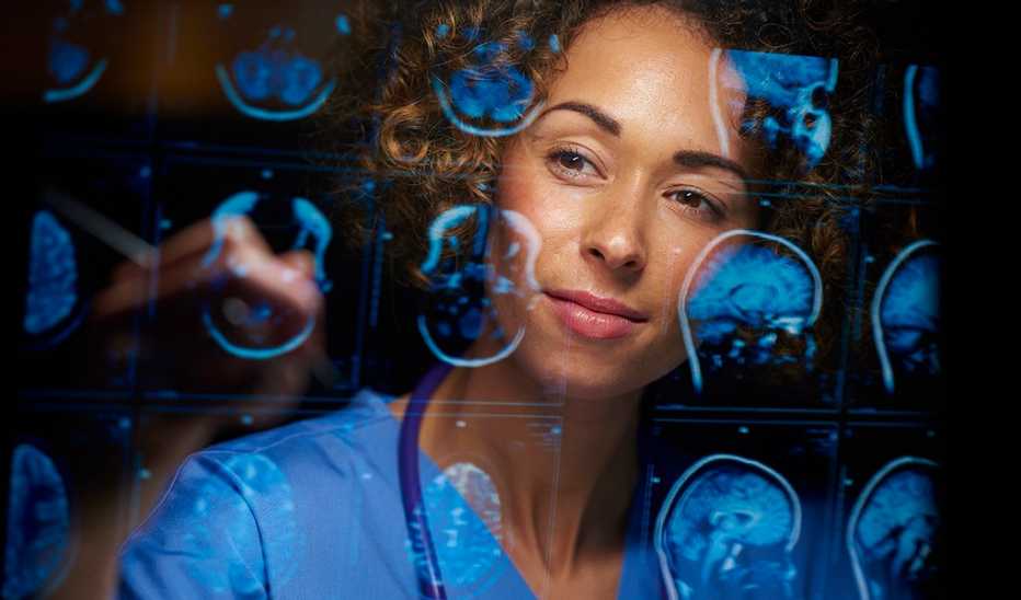 A female doctor looking at MRI scans of human brains