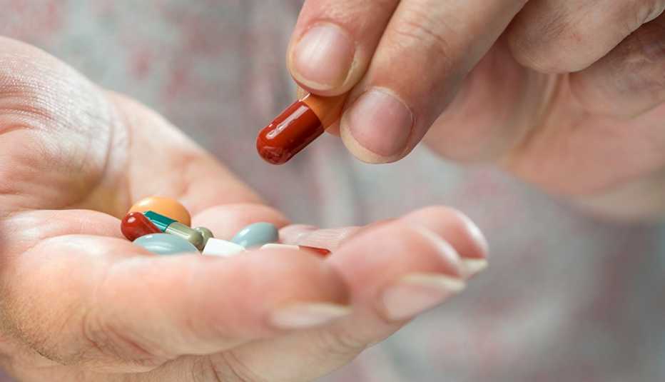 A close-up view of a hand full of pills and supplements