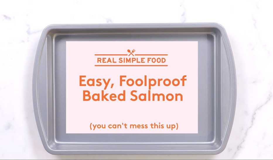 A close-up view of a baking pan with the text "real simple food," easy, foolproof baked salmon" and "(you can't mess this up)"