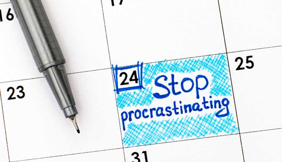 A close-up view of a calendar with "Stop procrastinating" written on it