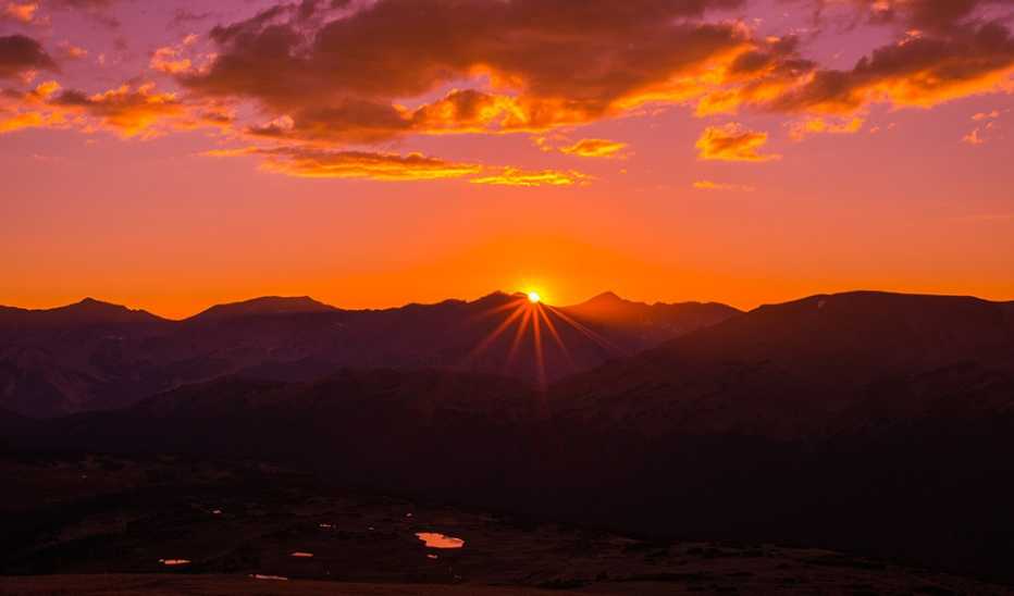 The sun setting behind a mountain