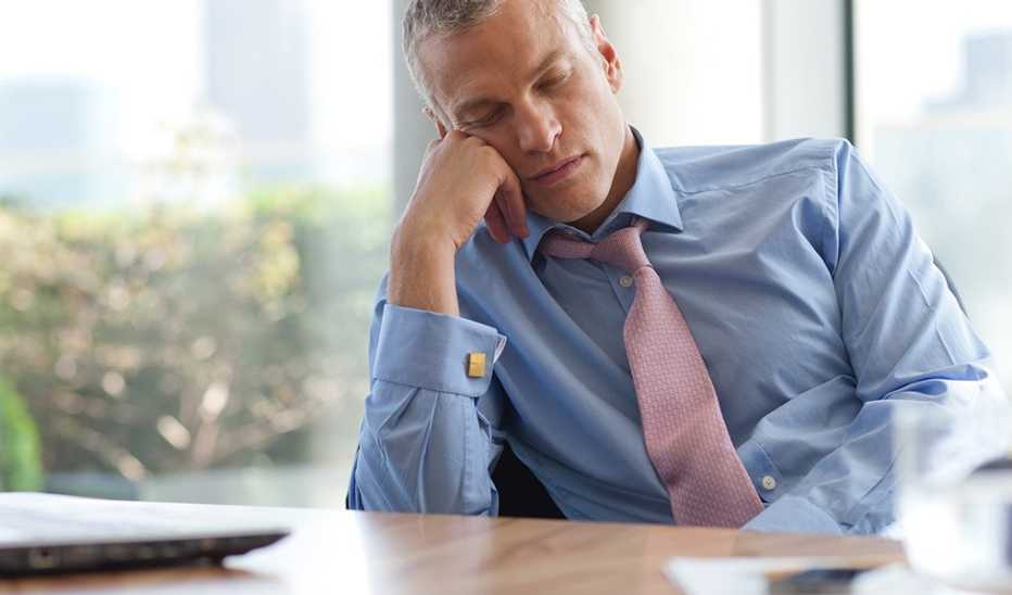 A man sleeping at a desk in an office