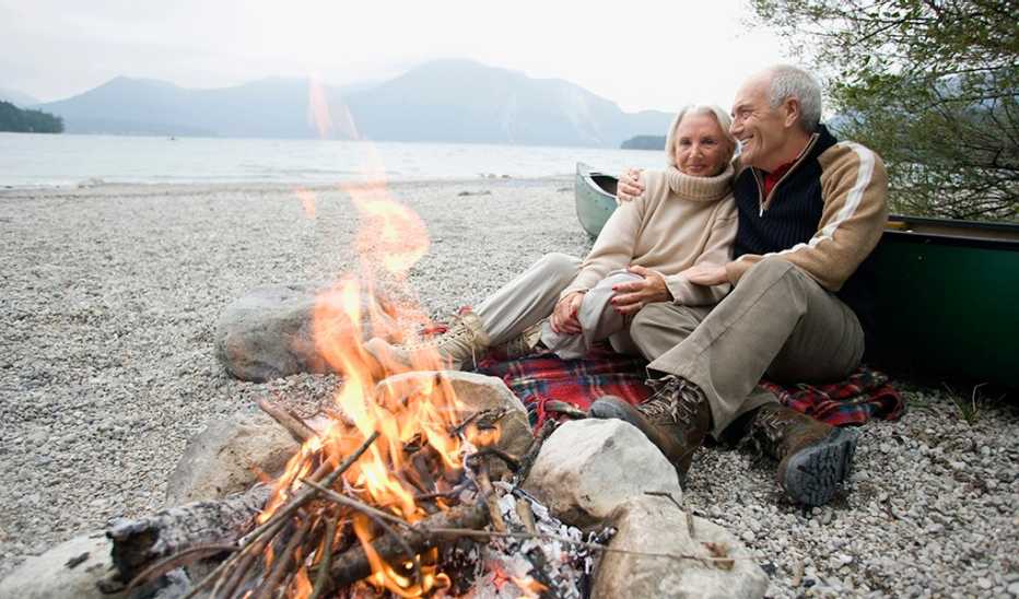 A man and woman sitting together by a campfire