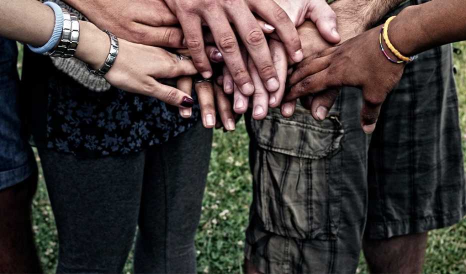 An up-close view of several hands touching each other