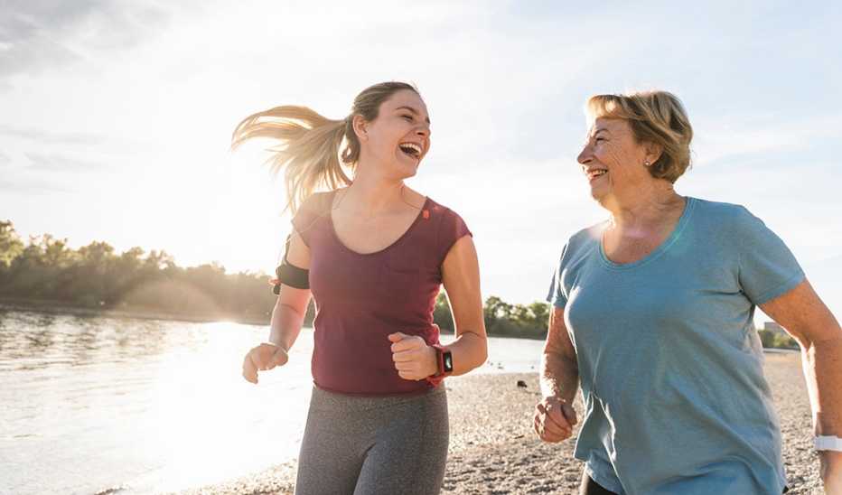 Two women running together along a river