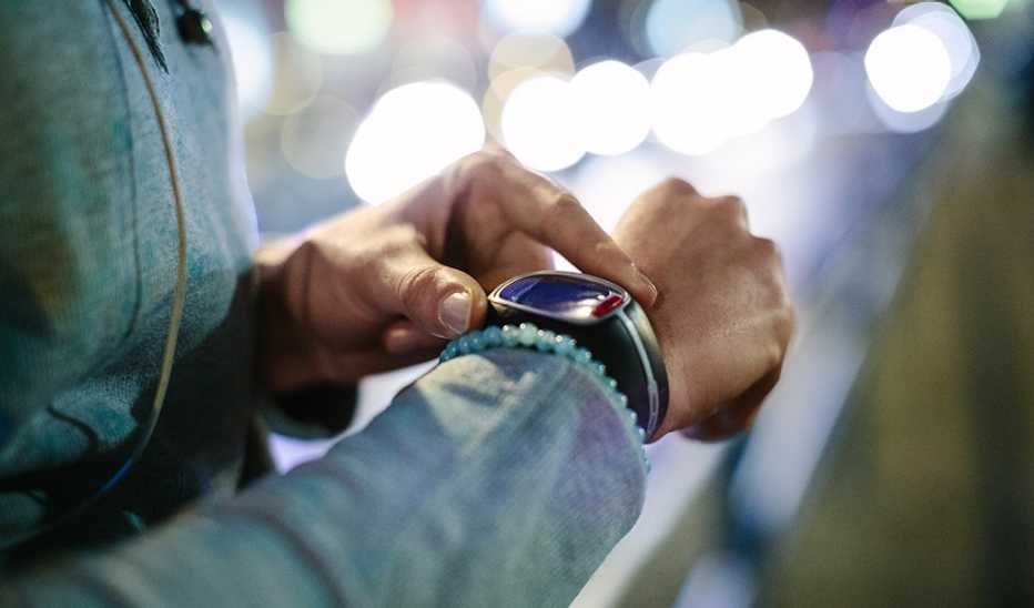A close-up view of a person touching their watch on their wrist