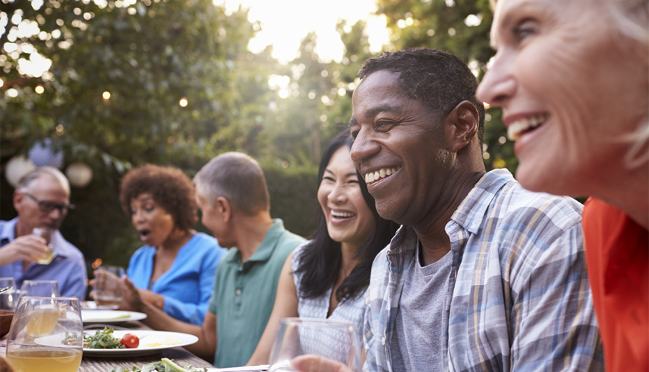 A group of friends enjoying an outdoor meal together in a backyard