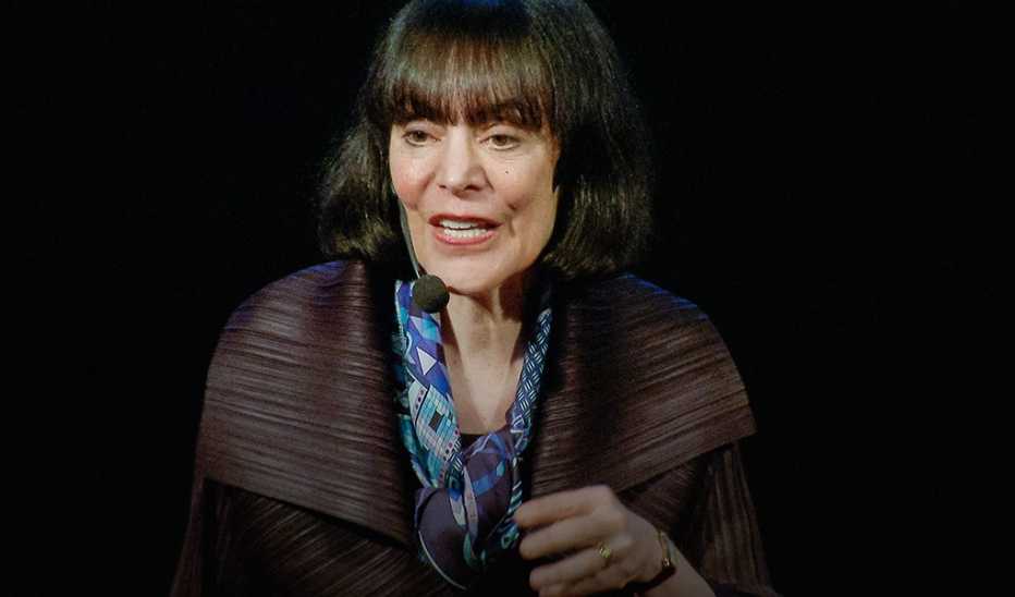 A woman, Carol Dweck, speaking on stage at a TED event