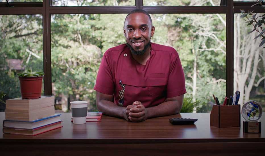 A man, Robert A. Belle, smiling and sitting at a desk