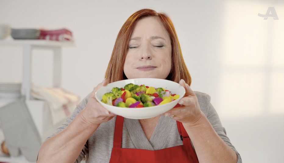 A woman with her eyes closed smelling a bowl of fry replacements