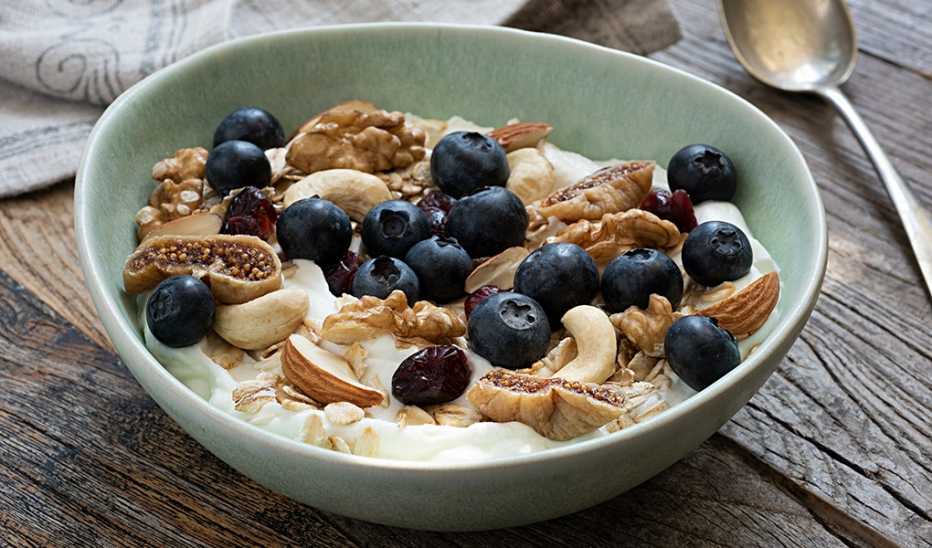 A close-up view of a muesli bowl with blueberries and nuts