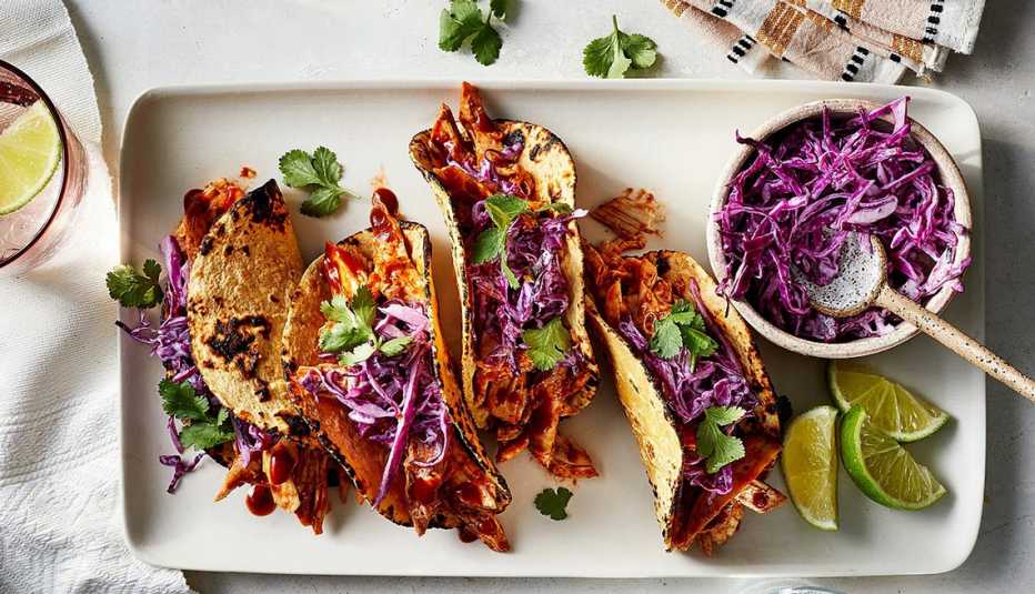 BBQ chicken tacos with red cabbage slaw A close-up view of BBQ chicken tacos with red cabbage slaw on a tray