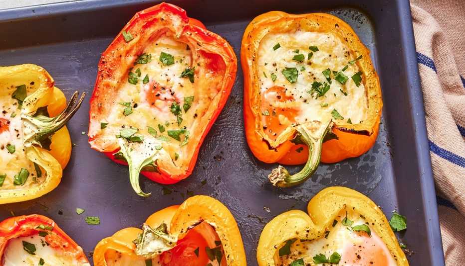 3-ingredient bell pepper and cheese egg cups A close-up view of three-ingredient bell pepper and cheese egg cups on a sheet pan