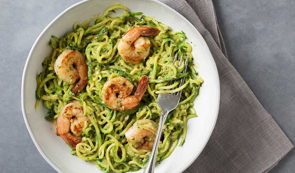 Zucchini noodles with avocado pesto and shrimp A close-up view of zucchini noodles with avocado pesto and shrimp in a bowl