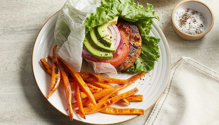 California turkey burgers and baked sweet potato fries A close-up view of a California turkey burger and baked sweet potato fries on a plate