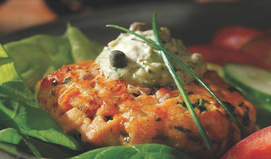 A close-up view of salmon burgers with green goddess sauce
