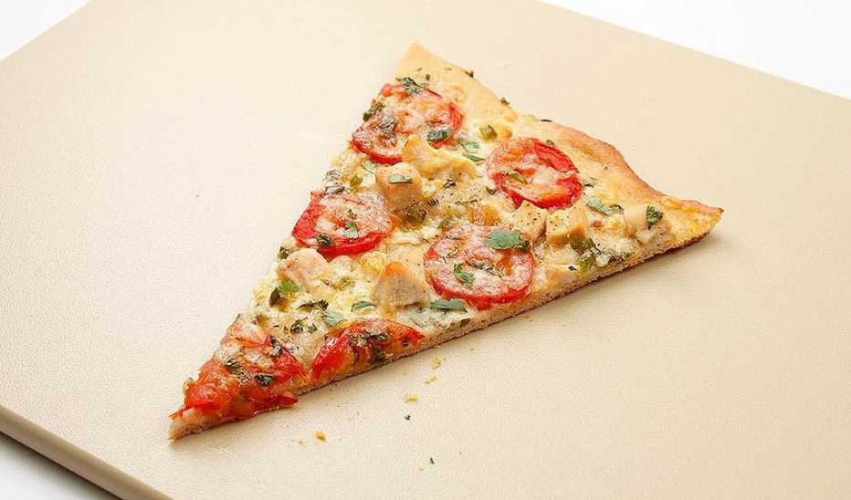 A close-up view of chicken, tomato and jalapeño pizza