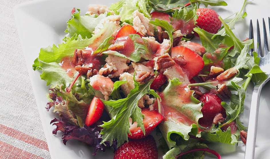 A close-up view of salmon salad with strawberry vinaigrette on a plate